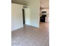 Open-concept living room with tiled floors leading into updated kitchen space at 3120 N 67Th Ln # 17, Phoenix, AZ 85033