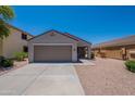 Charming single-story home featuring a two-car garage, desert landscaping, and a well-maintained front yard at 37053 W Amalfi Ave, Maricopa, AZ 85138