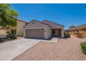 Single-story home featuring a two-car garage, desert landscaping, and a well-maintained front yard at 37053 W Amalfi Ave, Maricopa, AZ 85138