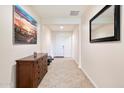 Neutral hallway featuring tiled floors, a decorative mirror, and a wooden dresser at 4032 S Santa Rita Pl, Chandler, AZ 85249