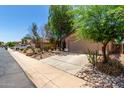Street view of a single-story home with desert landscaping, a long driveway, and a two-car garage at 43875 W Baker Dr, Maricopa, AZ 85138