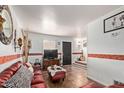 Cozy living room with red leather furniture, decorative accents, and easy access to other areas at 4515 N 26Th Dr, Phoenix, AZ 85017