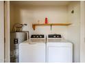Inside laundry room with washer, dryer, hot water heater and utility shelf at 5249 E Shea Blvd # 215, Scottsdale, AZ 85254