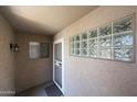 A private porch featuring a security door, glass block window and outdoor lantern at 5249 E Shea Blvd # 215, Scottsdale, AZ 85254