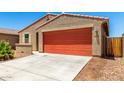 Close-up of a single-story home featuring a two-car garage, low maintenance landscaping, and a classic stucco facade at 5626 W Rainwater Dr, Laveen, AZ 85339