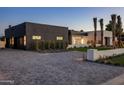Stylish modern home exterior with brick driveway, black accents, and manicured landscaping at 6303 E Via Estrella Ave, Paradise Valley, AZ 85253