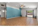 Open living room with bright accent wall, ceiling fan, and sliding glass doors to the backyard at 10646 E Enid Ave, Mesa, AZ 85208