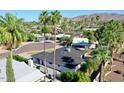 An aerial view of the house, palm trees, and mountains at 10844 N 37Th Way, Phoenix, AZ 85028
