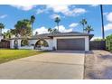 A home featuring a lush green lawn, desert plants, and a two-car garage sits below a beautiful partly cloudy sky at 10844 N 37Th Way, Phoenix, AZ 85028