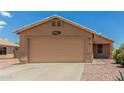 Beige single-story house with a large garage and desert landscaping at 1180 W Rosal Ave, Apache Junction, AZ 85120