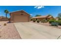 Single story home featuring desert landscaping, large driveway, and two-car garage at 1180 W Rosal Ave, Apache Junction, AZ 85120