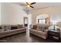 Open living room with neutral walls, hardwood floors, and comfortable seating with decorative pillows at 12410 W Flores Dr, El Mirage, AZ 85335
