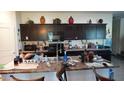 A cluttered kitchen featuring dark wood cabinets, granite countertops and modern appliances at 1309 W Park St, Phoenix, AZ 85041