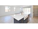 Open-concept kitchen featuring an island with a white countertop, a farmhouse sink, and modern fixtures at 1661 N St Francis Pl, Casa Grande, AZ 85122