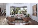 Bright living room featuring a large curved window overlooking the backyard pool and landscaping at 22020 N Church Rd, Scottsdale, AZ 85255
