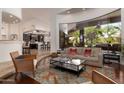 Living room with large window overlooking the pool area, open to kitchen with bar seating at 22020 N Church Rd, Scottsdale, AZ 85255