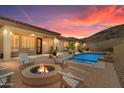 Relaxing backyard with a pool, fire pit, seating, and desert views at sunset at 2722 W Hiddenview Dr, Phoenix, AZ 85045