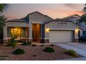 Inviting single-story home featuring a desert landscape, two-car garage, and cozy front porch at 29819 W Whitton Ave, Buckeye, AZ 85396