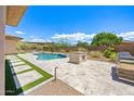 Beautiful backyard with a sparkling pool, outdoor kitchen area, travertine tile, and desert landscaping at 31107 N 72Nd Pl, Scottsdale, AZ 85266