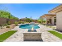 Backyard oasis featuring a pool, spa, fire pit, built-in grill, lush landscaping, and artificial turf at 31107 N 72Nd Pl, Scottsdale, AZ 85266