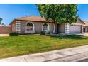 Well-maintained home with a manicured lawn, desert landscaping, arched windows, and a two-car garage at 3619 E Thornton Ave, Gilbert, AZ 85297