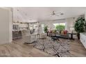 Open-concept living room with wood floors, neutral decor, ceiling fan, and abundant natural light at 3619 E Thornton Ave, Gilbert, AZ 85297