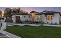 Beautiful exterior featuring a well-manicured lawn, black accents, and a freshly painted white facade at 3848 E Fairmount Ave, Phoenix, AZ 85018