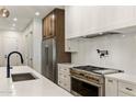Gourmet kitchen with quartz countertops, stainless steel appliances, a pot filler, and designer finishes at 3848 E Fairmount Ave, Phoenix, AZ 85018