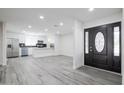 Bright entryway leading to a kitchen with stainless steel appliances and gray flooring at 4116 W Marshall Ave, Phoenix, AZ 85019