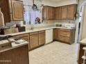 Well-lit kitchen with tile flooring, plenty of counterspace, and ample wood cabinet storage at 4301 E Amberwood Dr, Phoenix, AZ 85048