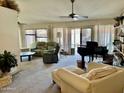 Cozy living room with plush seating, ceiling fan, and sliding glass doors to the pool area at 4301 E Amberwood Dr, Phoenix, AZ 85048