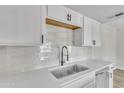 Bright kitchen featuring white cabinets, subway tile backsplash, and stainless steel sink at 4714 E Broadway Rd, Phoenix, AZ 85040