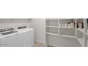 A well-equipped laundry room with ample storage shelves and modern washer and dryer units at 6999 S Blue Hills Dr, Buckeye, AZ 85326