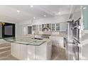 Modern kitchen with stainless steel appliances, sleek cabinetry, and a unique glass breakfast bar at 7376 E Via Estrella Ave, Scottsdale, AZ 85258