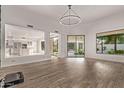 Open-concept living area featuring wood flooring, neutral walls, and access to the pool area at 7376 E Via Estrella Ave, Scottsdale, AZ 85258
