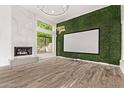 Modern theater room with sleek marble fireplace, an eye-catching accent wall and wood flooring at 7376 E Via Estrella Ave, Scottsdale, AZ 85258