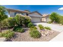 Beautiful home exterior with a two-car garage and low-maintenance desert landscaping at 9822 W Caron Dr, Peoria, AZ 85345