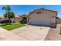 View of the home showcasing the two-car garage, desert landscaping, and tile roof at 12821 W Holly St, Avondale, AZ 85392