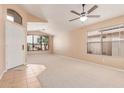 Spacious living room with carpet flooring, a ceiling fan, and lots of natural light streaming through the window at 12821 W Holly St, Avondale, AZ 85392