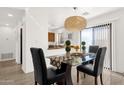 Cozy dining area with a glass table, pendant lighting, and a view of the kitchen at 13636 N Saguaro Blvd # 103, Fountain Hills, AZ 85268
