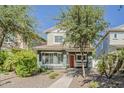 Charming two-story home with a welcoming red door, front porch swing, and mature landscaping at 1482 S Banning St, Gilbert, AZ 85296