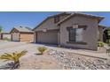 Inviting single-story home with a two-car garage and attractive desert landscaping at 15905 W Saguaro Ln, Surprise, AZ 85374
