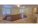 A bright living room with wood flooring, neutral walls, and windows that brings in natural light at 15905 W Saguaro Ln, Surprise, AZ 85374