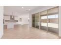 Open living space with ceramic tile flooring and large sliding glass doors leading to the outdoor area at 20262 W Monterey Way, Buckeye, AZ 85396