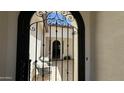 Charming courtyard view through the decorative iron gate, featuring neutral colors and seating at 2121 E Aquarius Pl, Chandler, AZ 85249