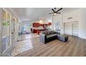 Spacious open-concept living room features wood-look flooring, and a view to the kitchen with a bar seating area at 23638 N 41St Ave, Glendale, AZ 85310
