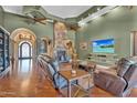 Cozy living room with a stone fireplace, hardwood floors, and a flat-screen TV at 2371 E Sanoque Ct, Gilbert, AZ 85298