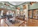 Open-concept living room featuring hardwood floors, a stacked stone feature wall, and built-in shelving at 2371 E Sanoque Ct, Gilbert, AZ 85298