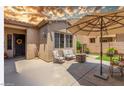 Charming outdoor patio featuring comfortable seating, fire pit and a shade umbrella for relaxing at 2554 E Honeysuckle Pl, Chandler, AZ 85286
