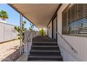 Mobile home stairway to a covered porch with white railings, desert landscaping and cacti at 2650 W Union Hills Dr # 269, Phoenix, AZ 85027